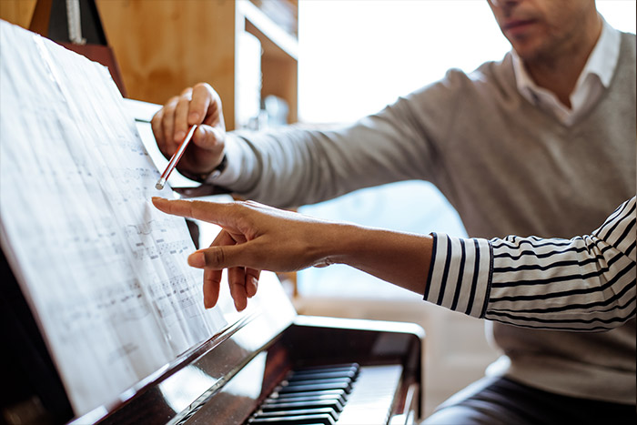 Man and lady hands pointing to sheet music