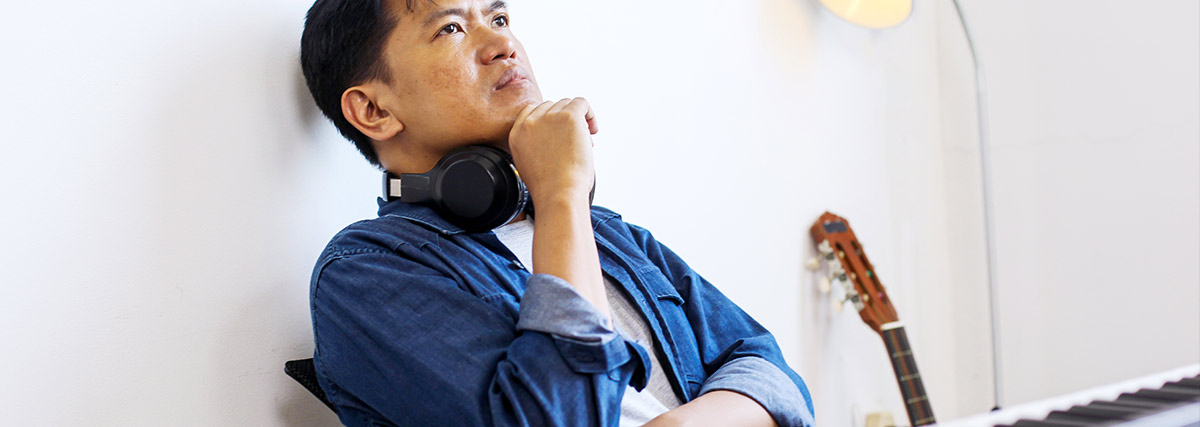 Man thinking in front of a piano