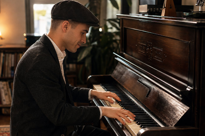 British jazz pianist with hat playing thumbs voicing in a room